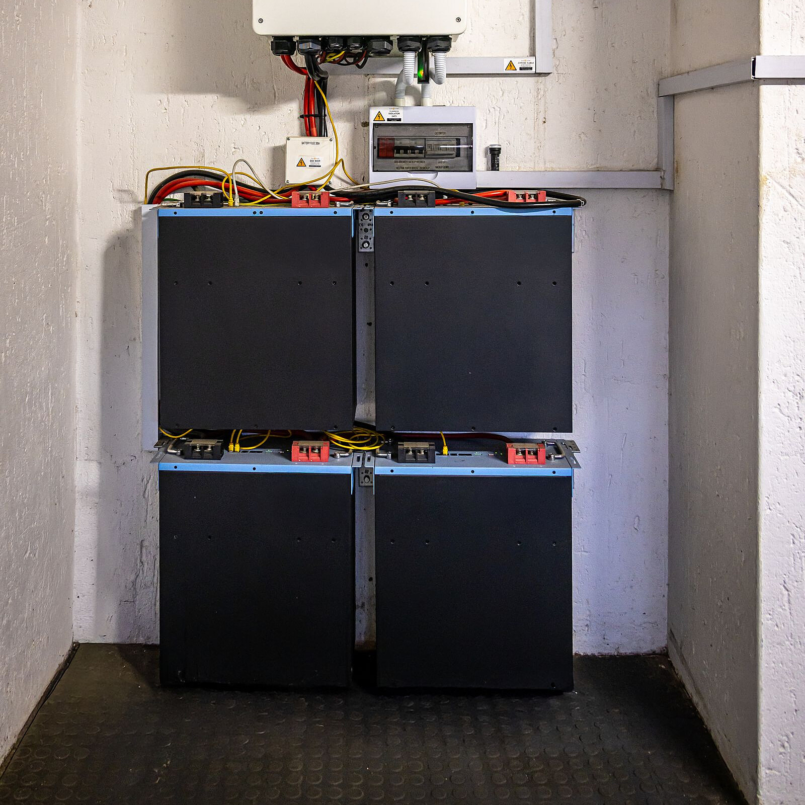 Thuisbatterij aan een muur in een nette technische ruimte
